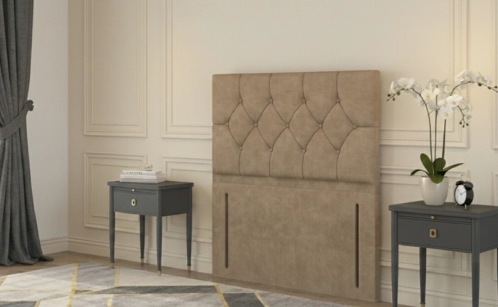 Chesterfield floor standing headboard in beige velvet, displayed between two black bedside tables in a classic interior.